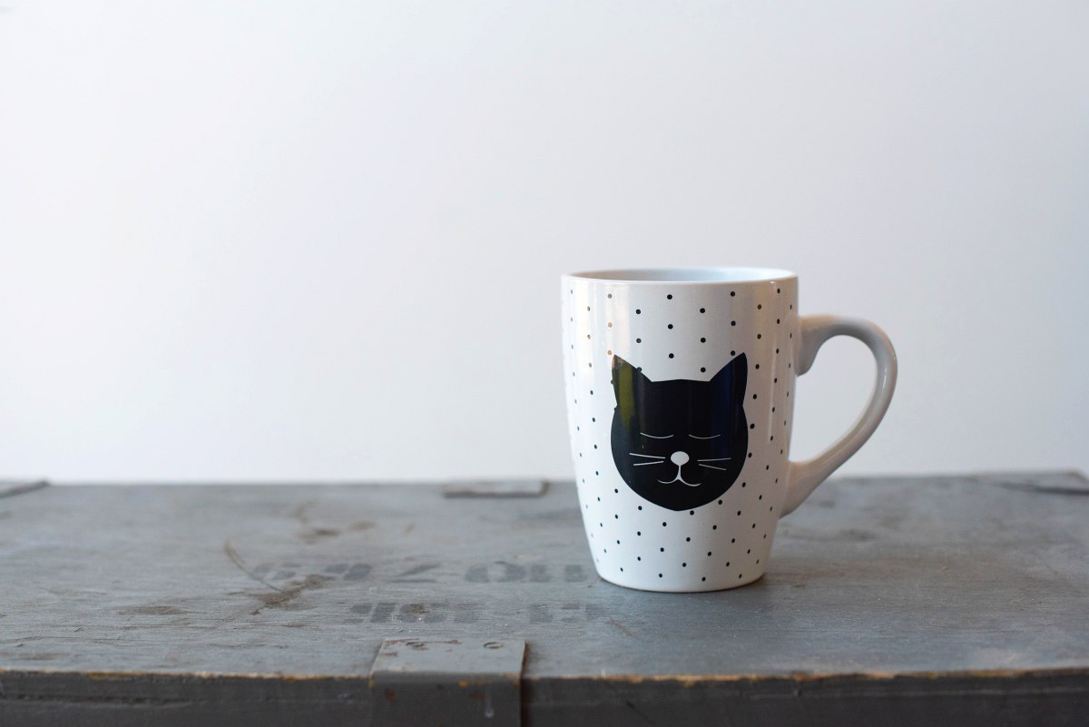 White cup with black dots and cat face. Matcha vs coffee?